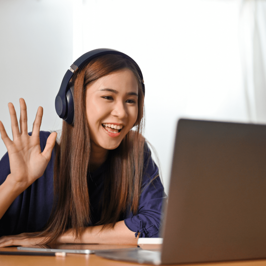 A joyful women in headphones engages with her laptop, representing the interactive nature of our online tutoring platform in the UAE